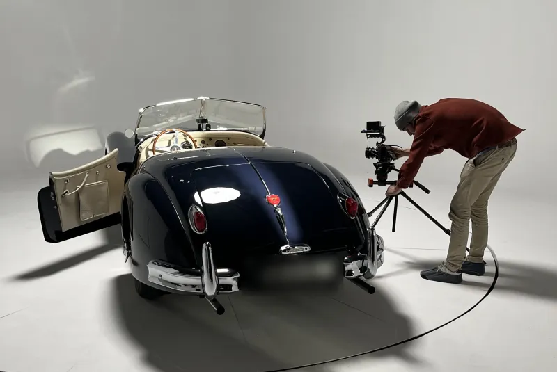 Shooting automobile : cabriolet ancien bleu nuit dans le studio, photographe en plein cadrage